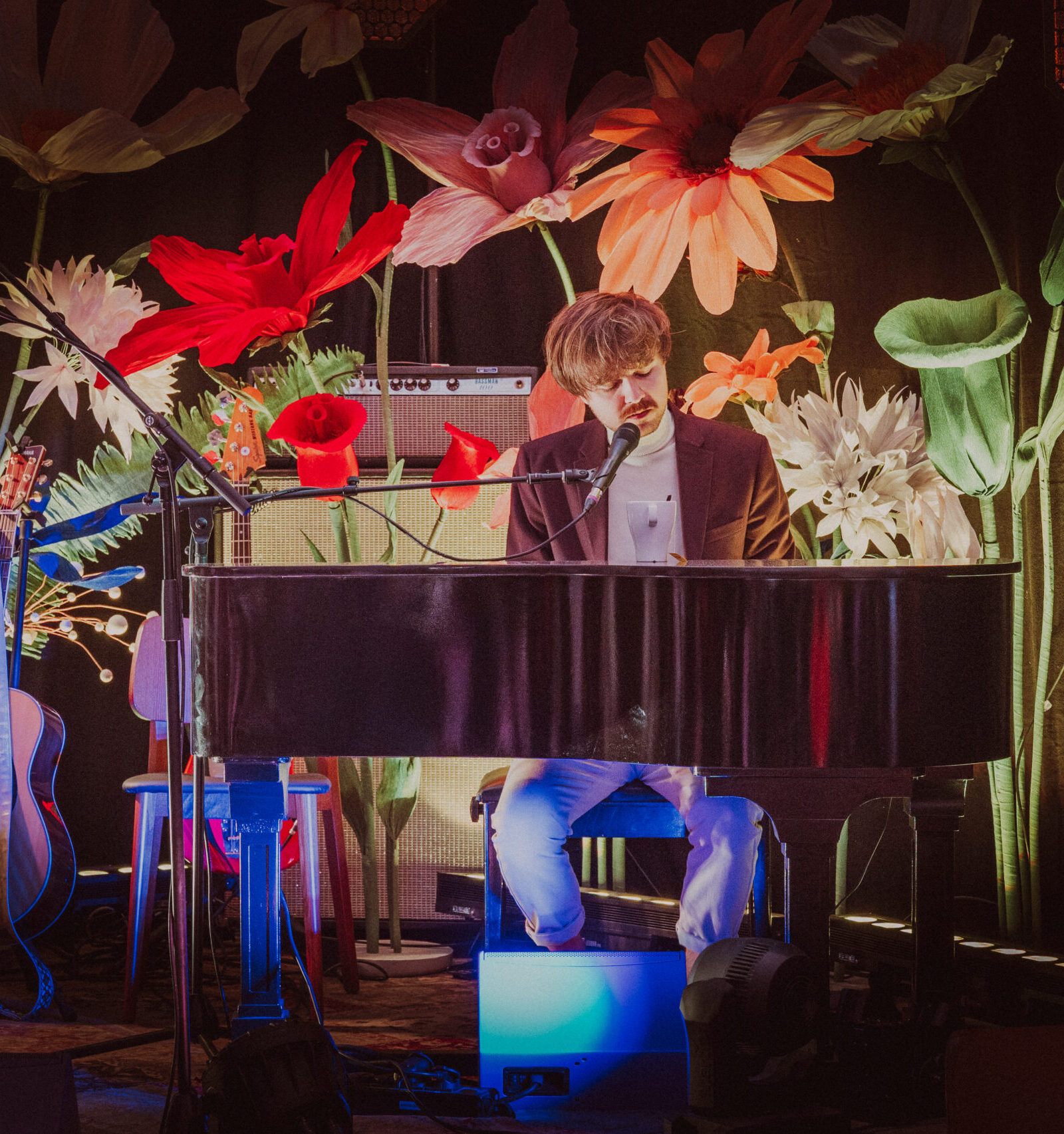 Anton Wernebäck spelar Piano på en scen med stora blommor på Hallands Matfest.